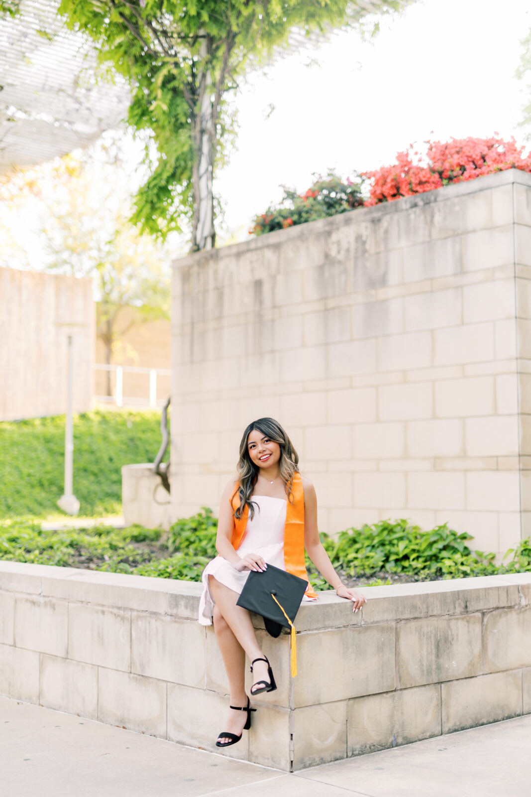UT Dallas senior posing for graduation photos on the UTD campus with meaningful landmarks in the background