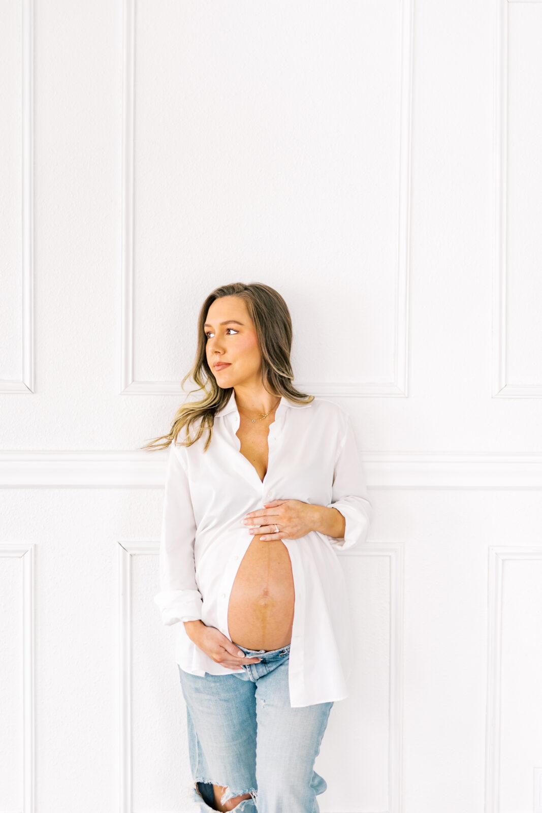 Expecting mother in Dallas holding baby bump during maternity photoshoot