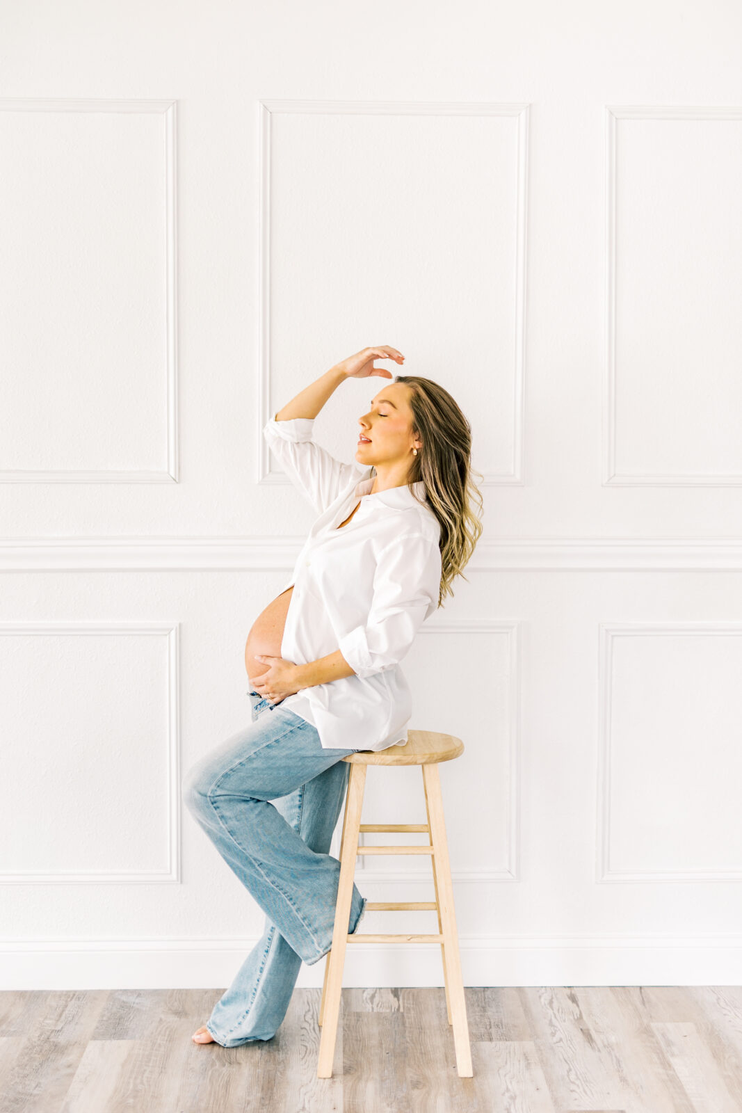 Expecting mother in Dallas holding baby bump during maternity photoshoot