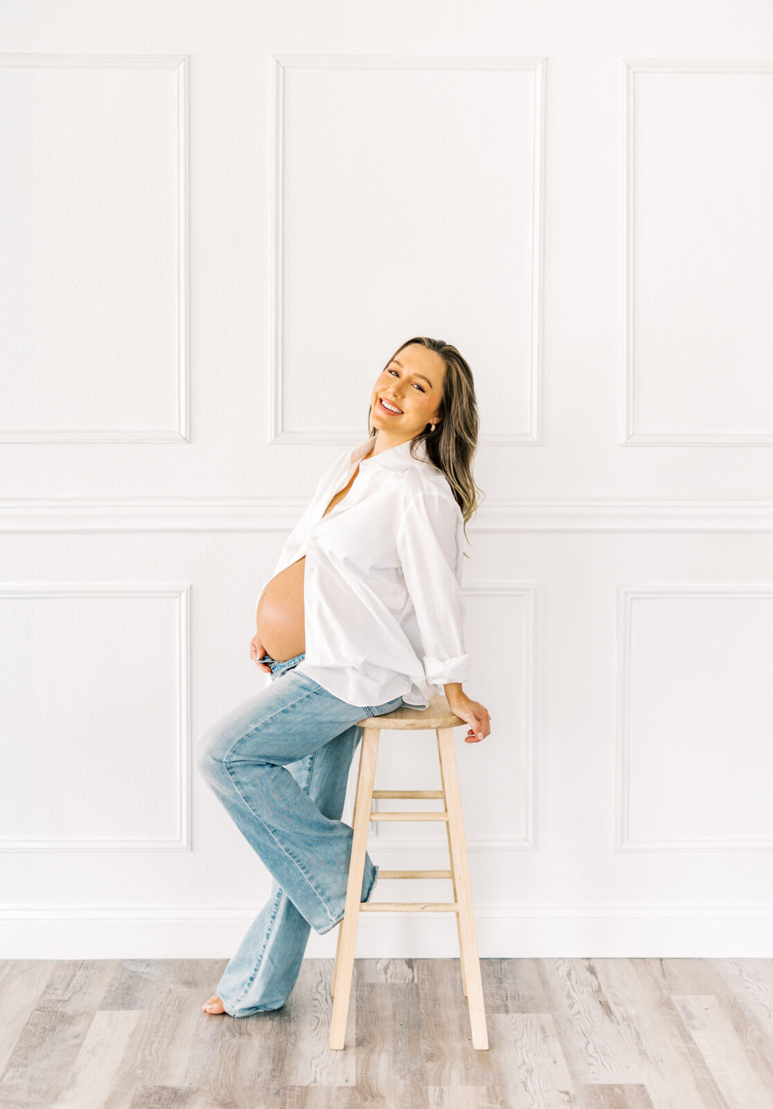 Expecting mother in Dallas holding baby bump during maternity photoshoot