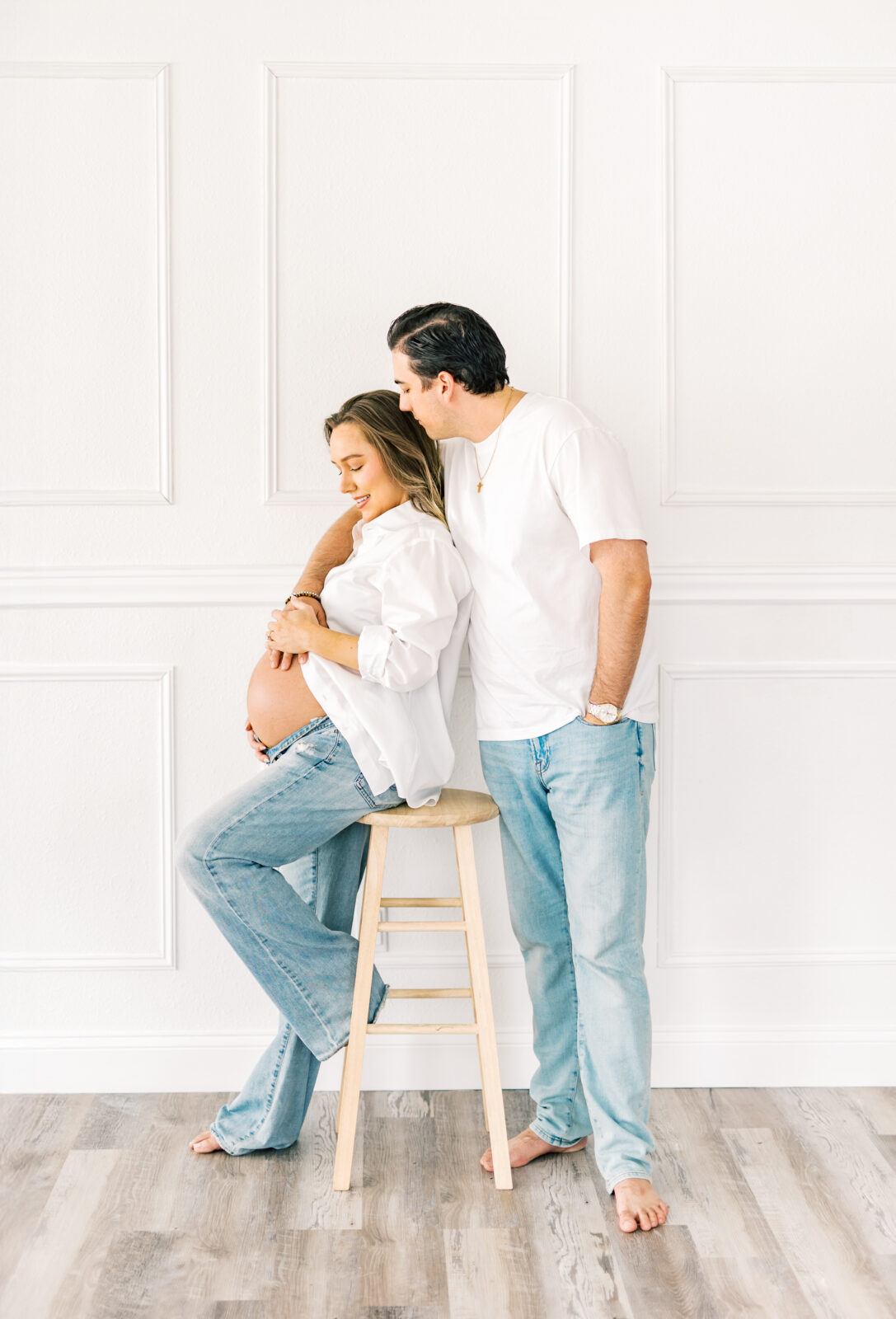 Expecting parents sitting together during Dallas maternity photography session at Ivory Dahlia Studio
