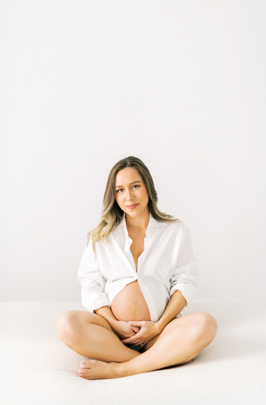 Mom-to-be in Dallas maternity session posing by natural window light
