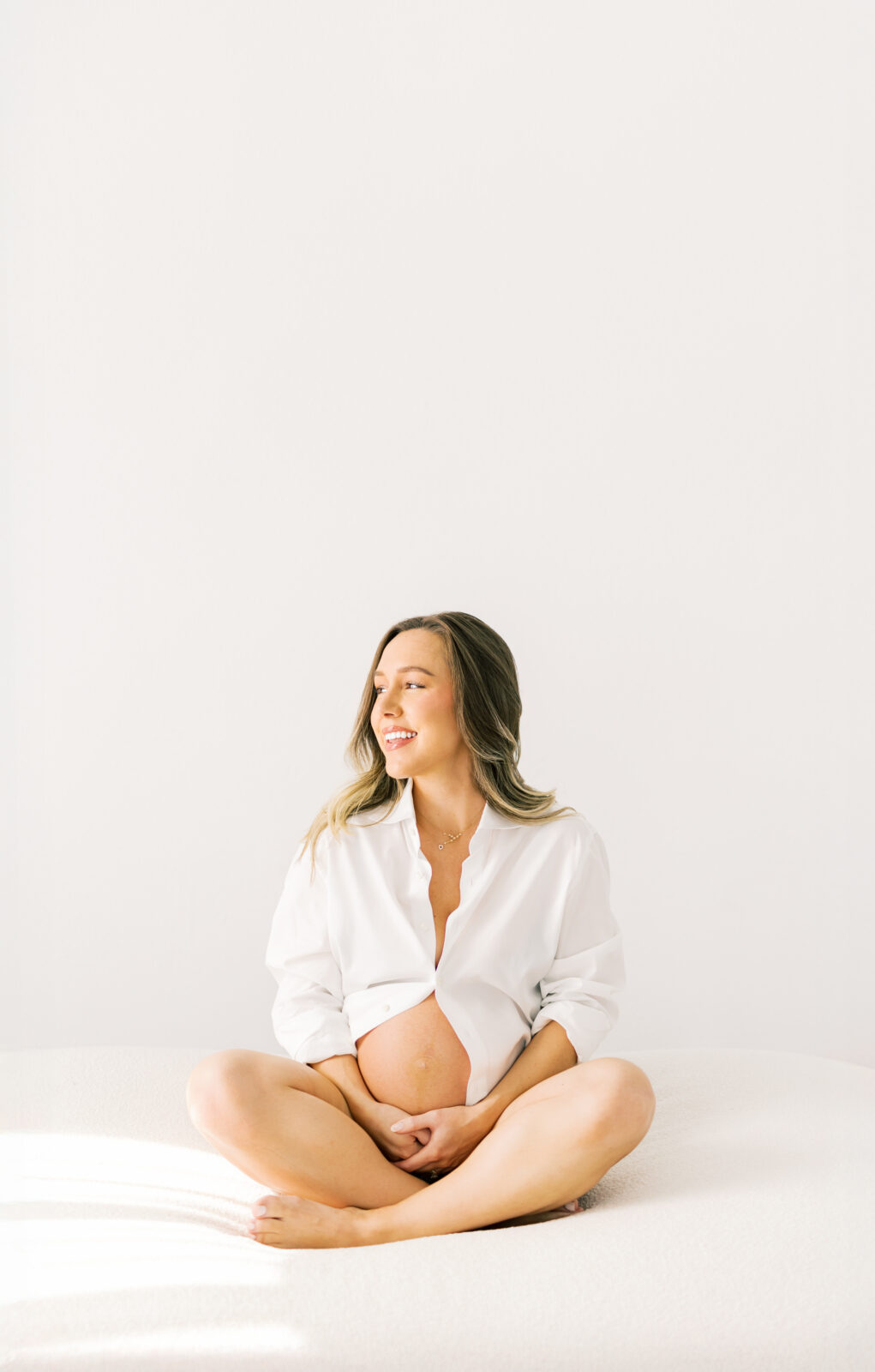 Expecting mother in Dallas holding baby bump during maternity photoshoot