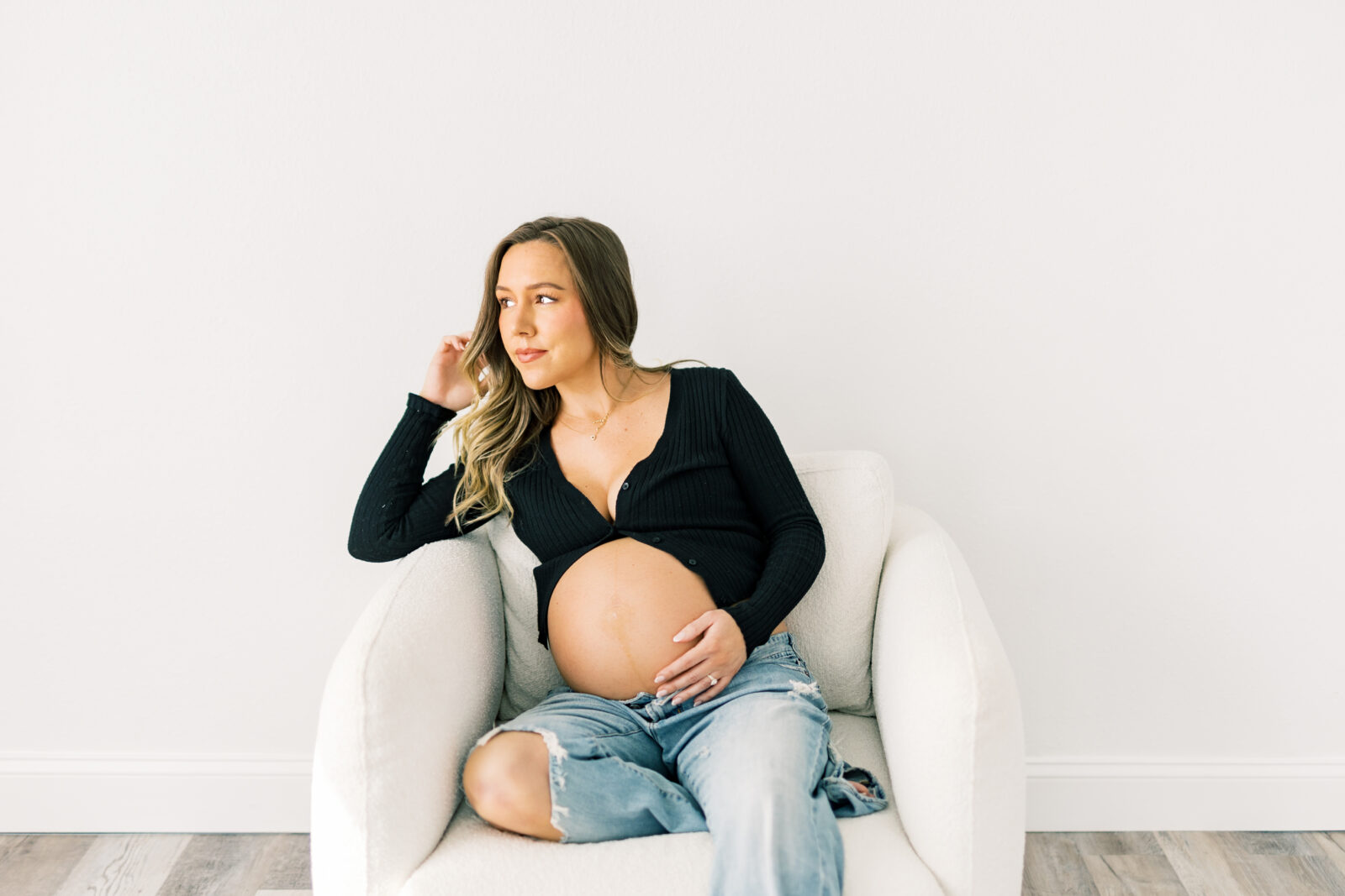 Maternity portrait of mother holding her baby bump in Dallas studio.