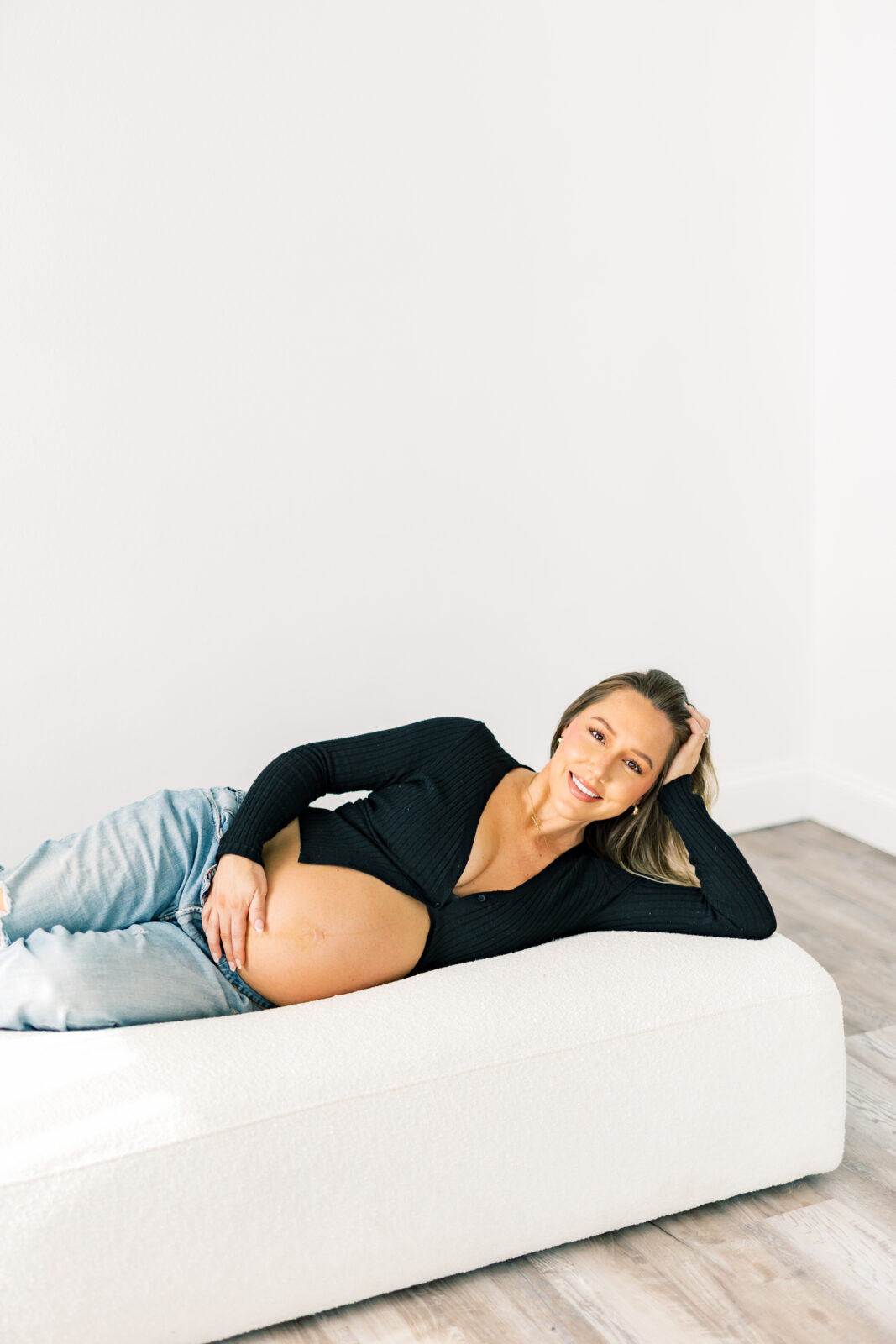 Dallas maternity photographer captures mom-to-be in denim and white button-down outfit