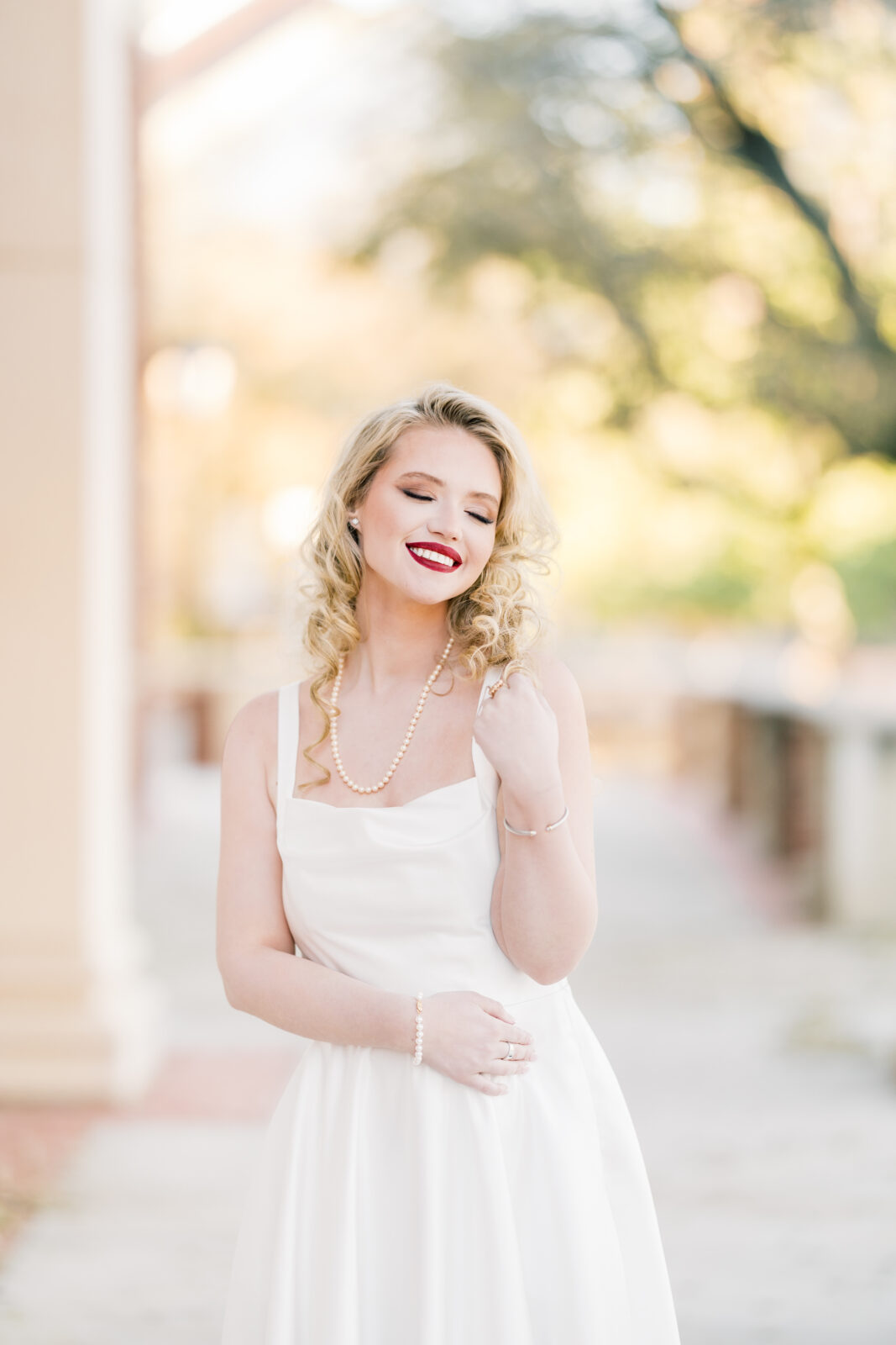very poses in her white dress at the Texas Woman’s University Student Union.