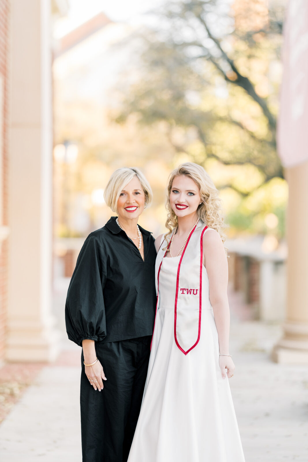 Avery and her mom smiling together during TWU graduation portraits.