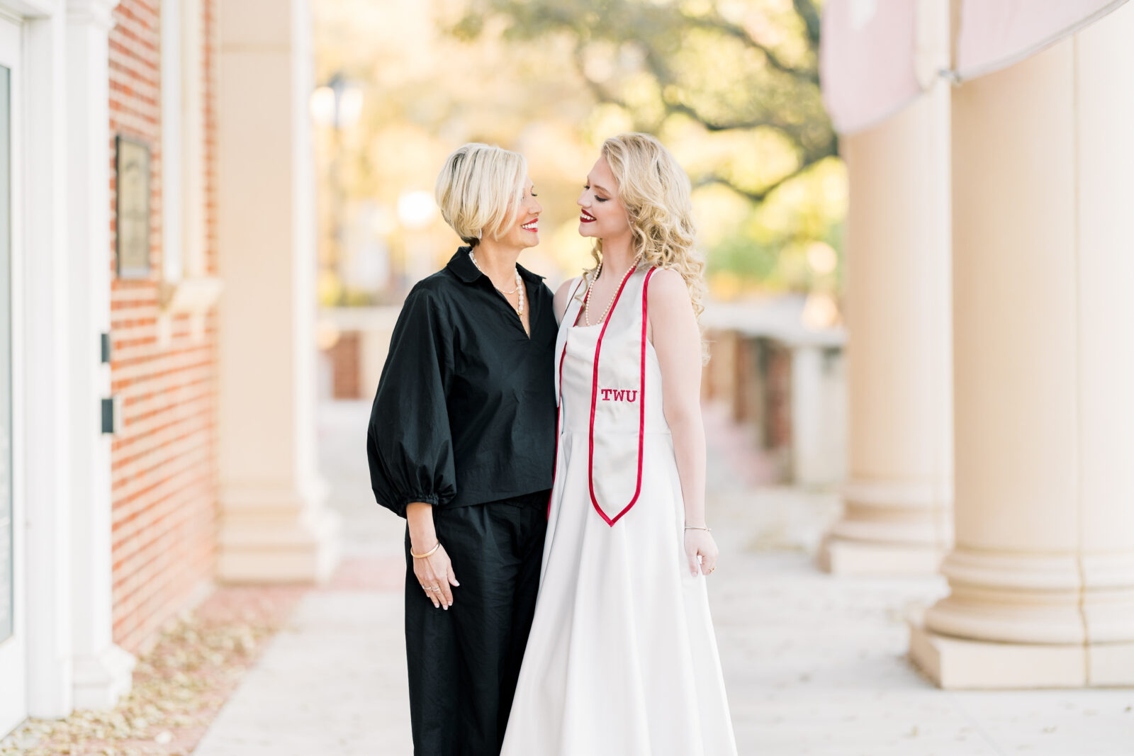 Avery and her mom smiling together during TWU graduation portraits.