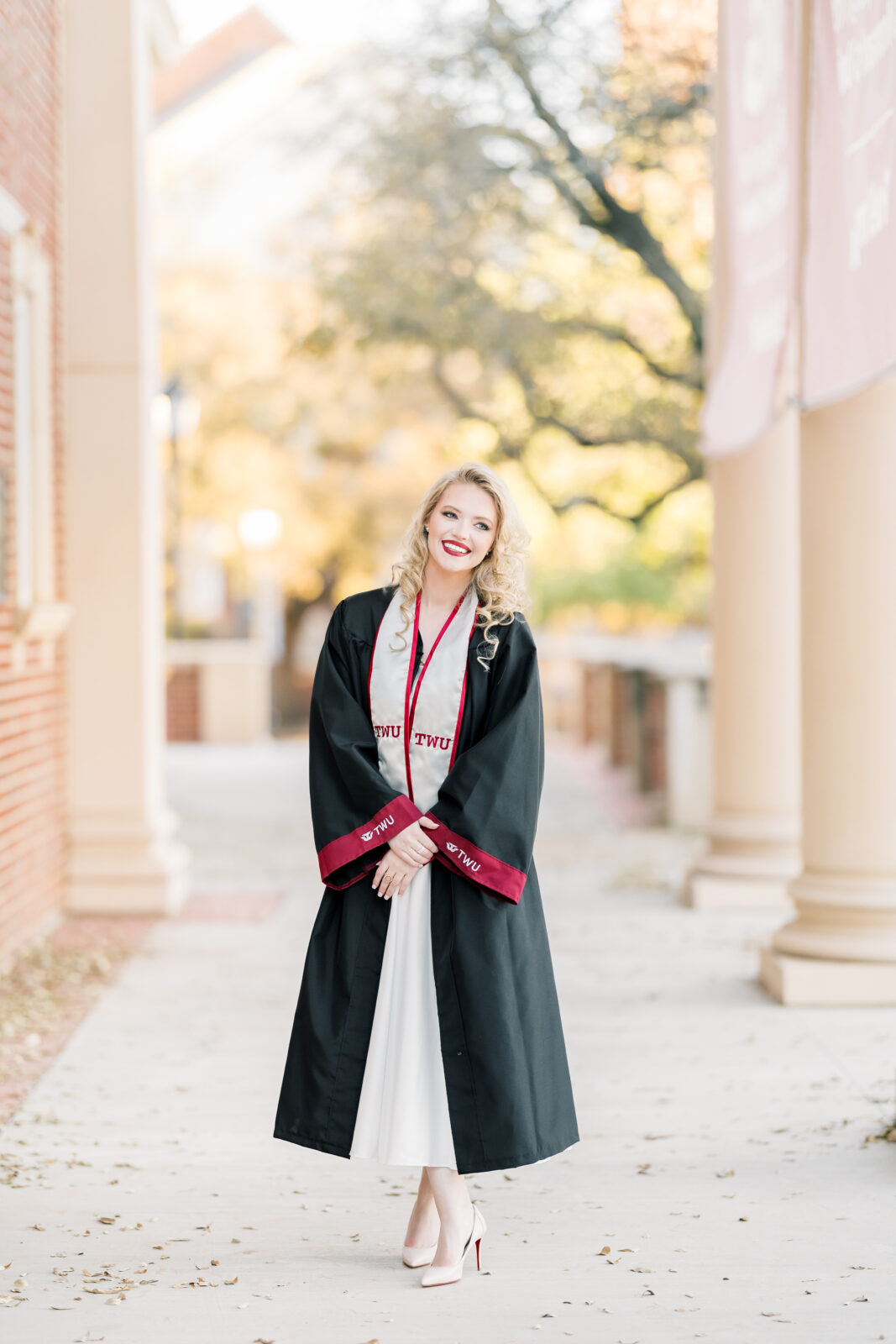 Avery in her cap and gown at the TWU Student Union for her Class of 2025 graduation portraits.