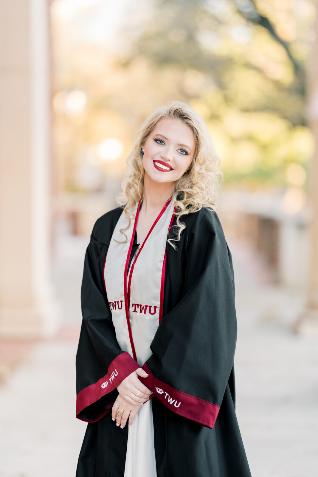 Avery in her cap and gown at the TWU Student Union for her Class of 2025 graduation portraits.