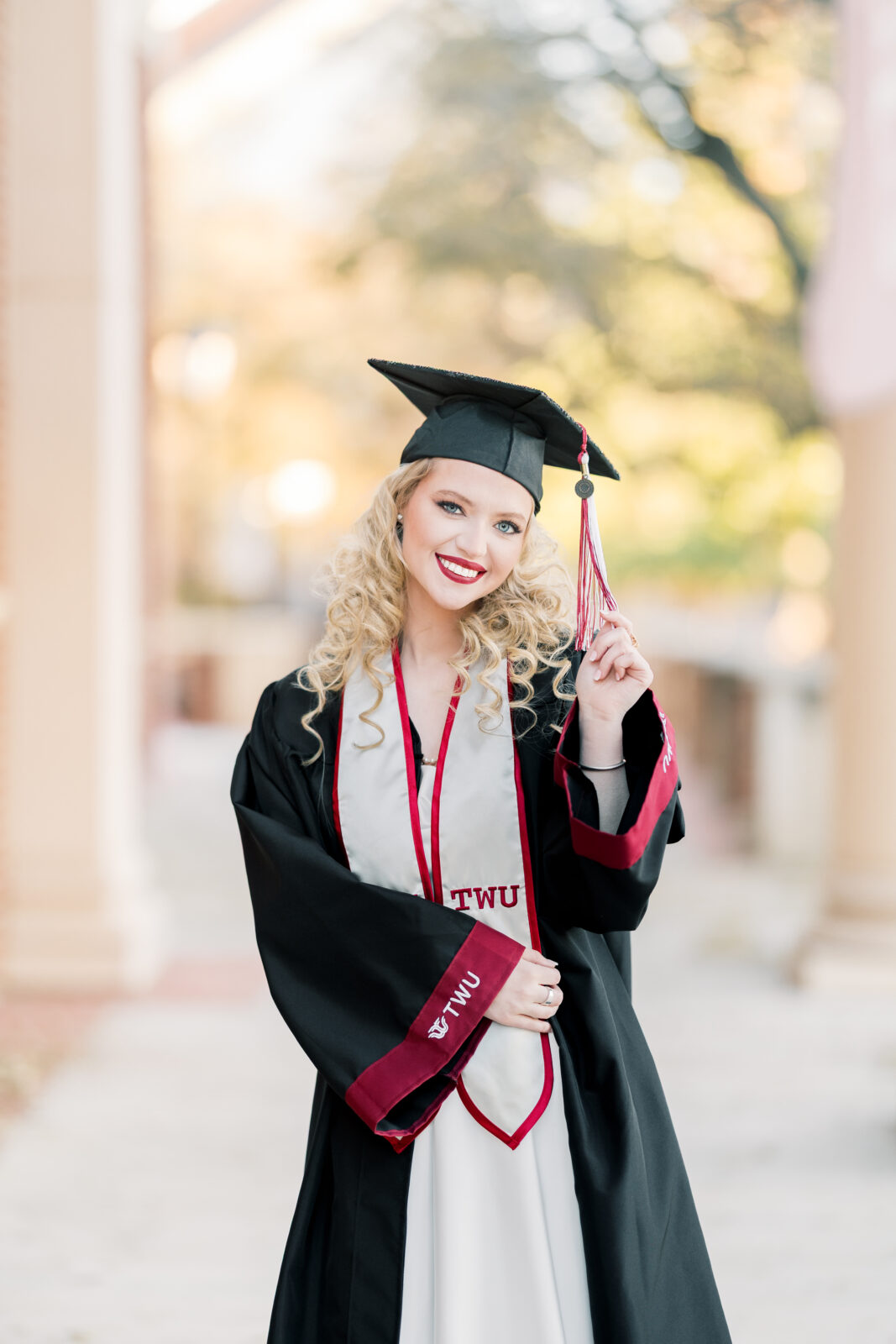 Avery in her cap and gown at the TWU Student Union for her Class of 2025 graduation portraits.