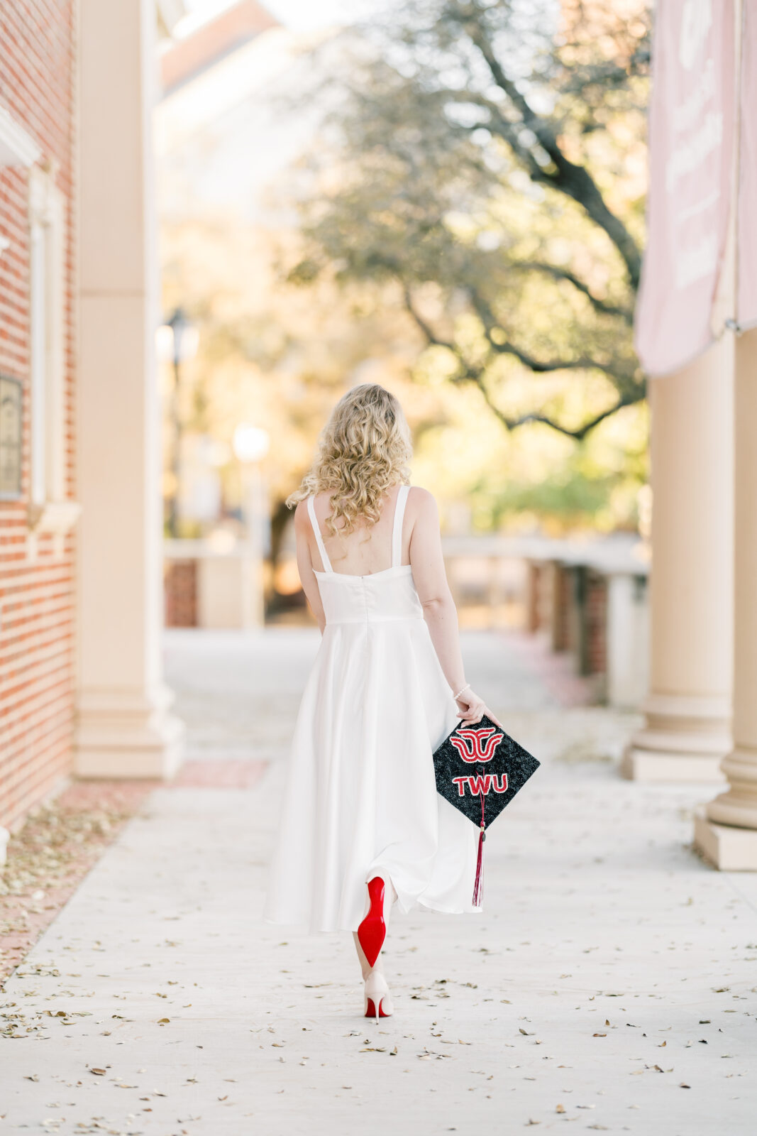 Avery walking in her Louboutins during Texas Woman’s University graduation photos.