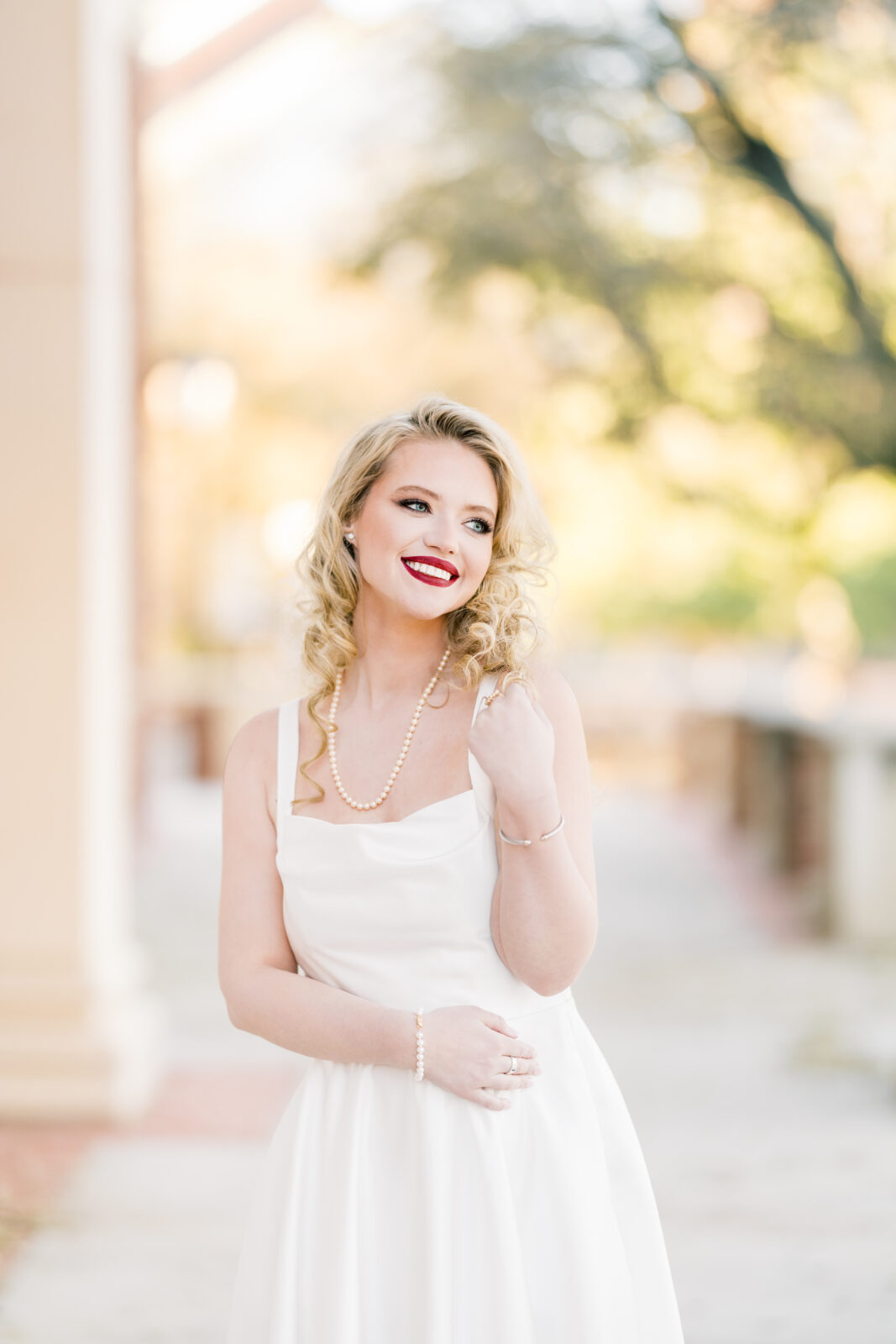 very poses in her white dress at the Texas Woman’s University Student Union.