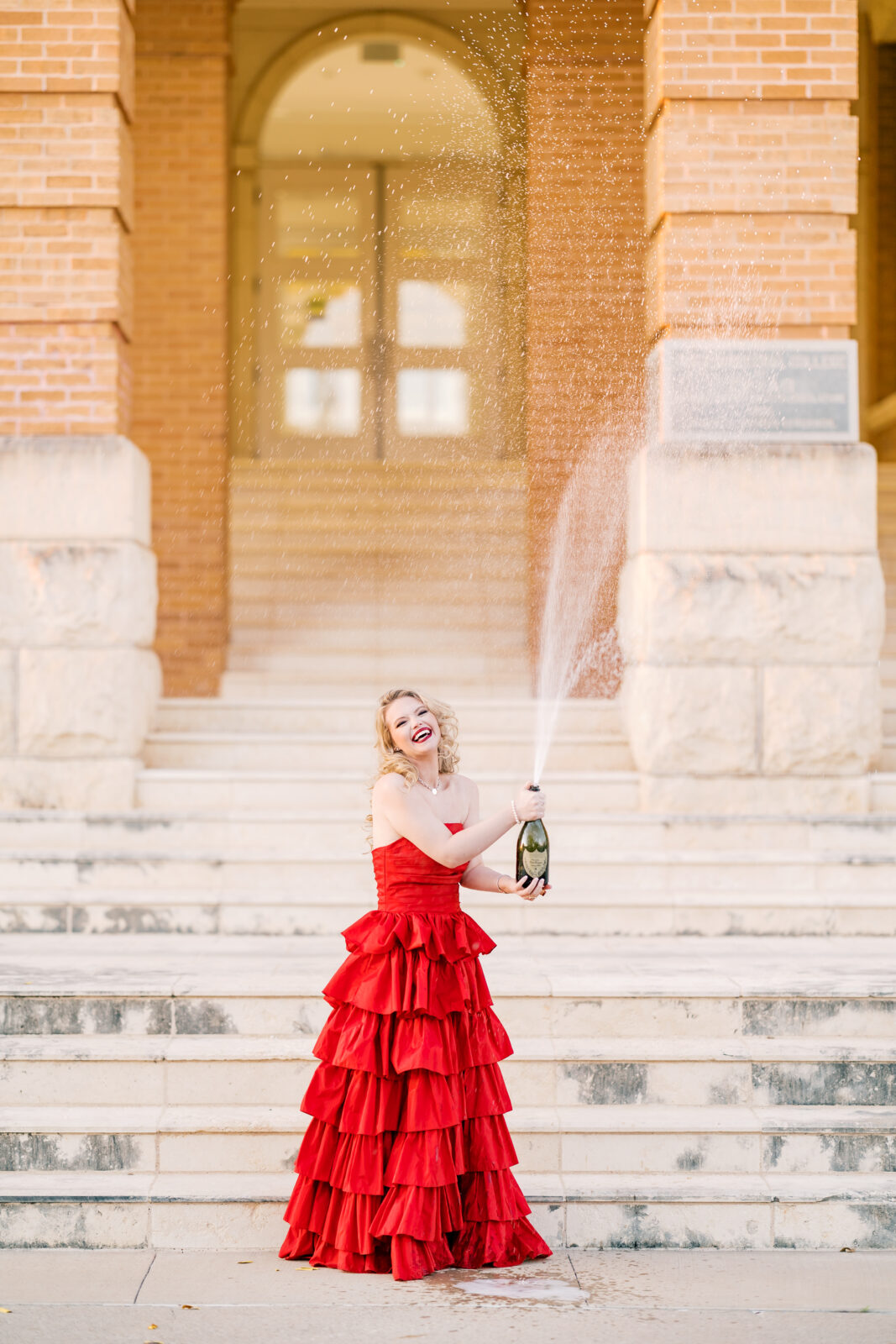 Avery pops a bottle of Dom Pérignon for her TWU graduation portraits.