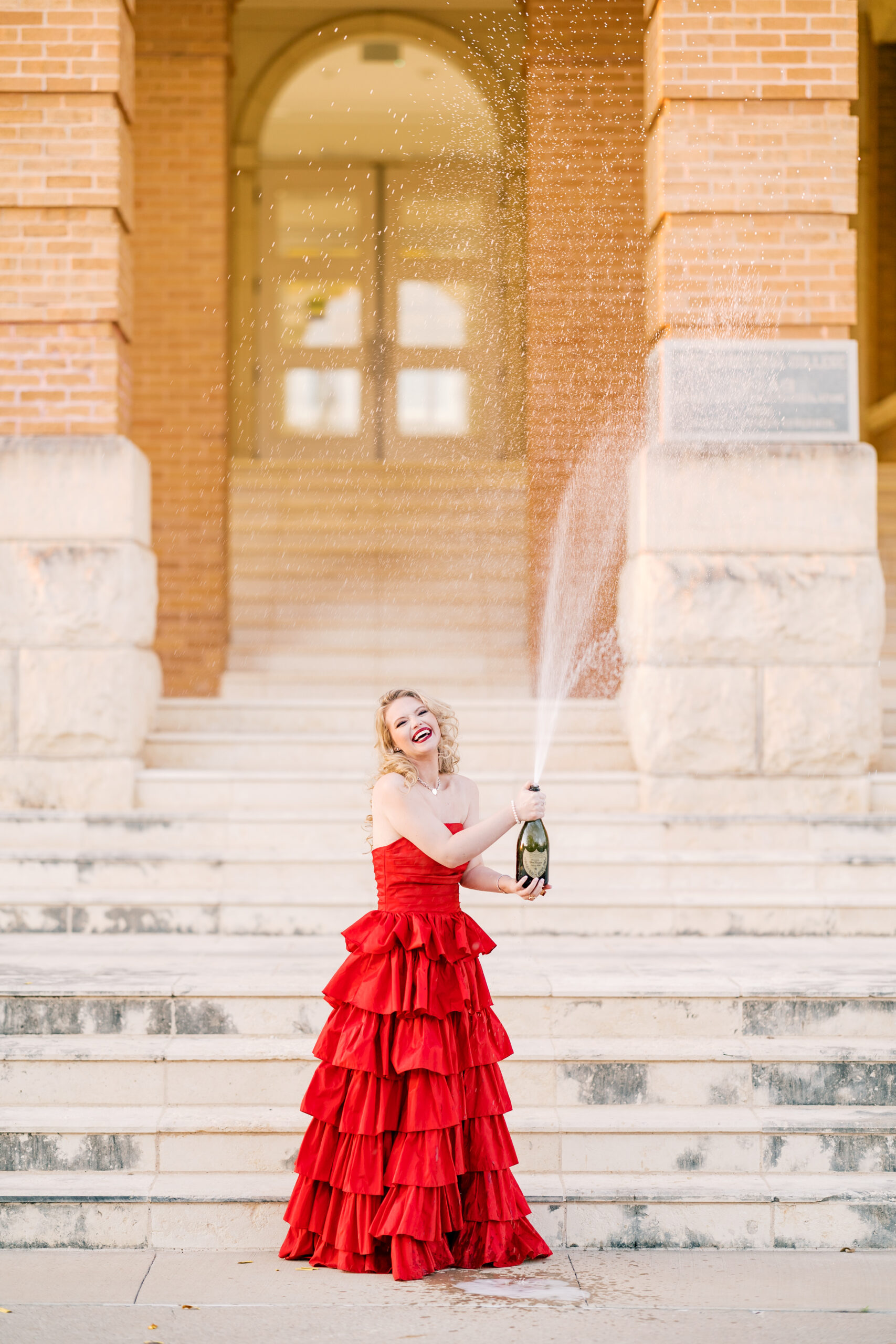 Avery pops a bottle of Dom Pérignon for her TWU graduation portraits.