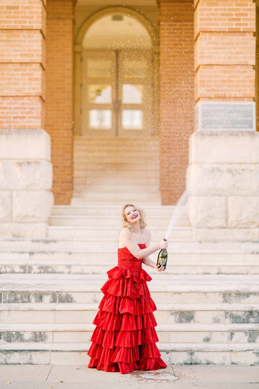 Avery pops a bottle of Dom Pérignon for her TWU graduation portraits.
