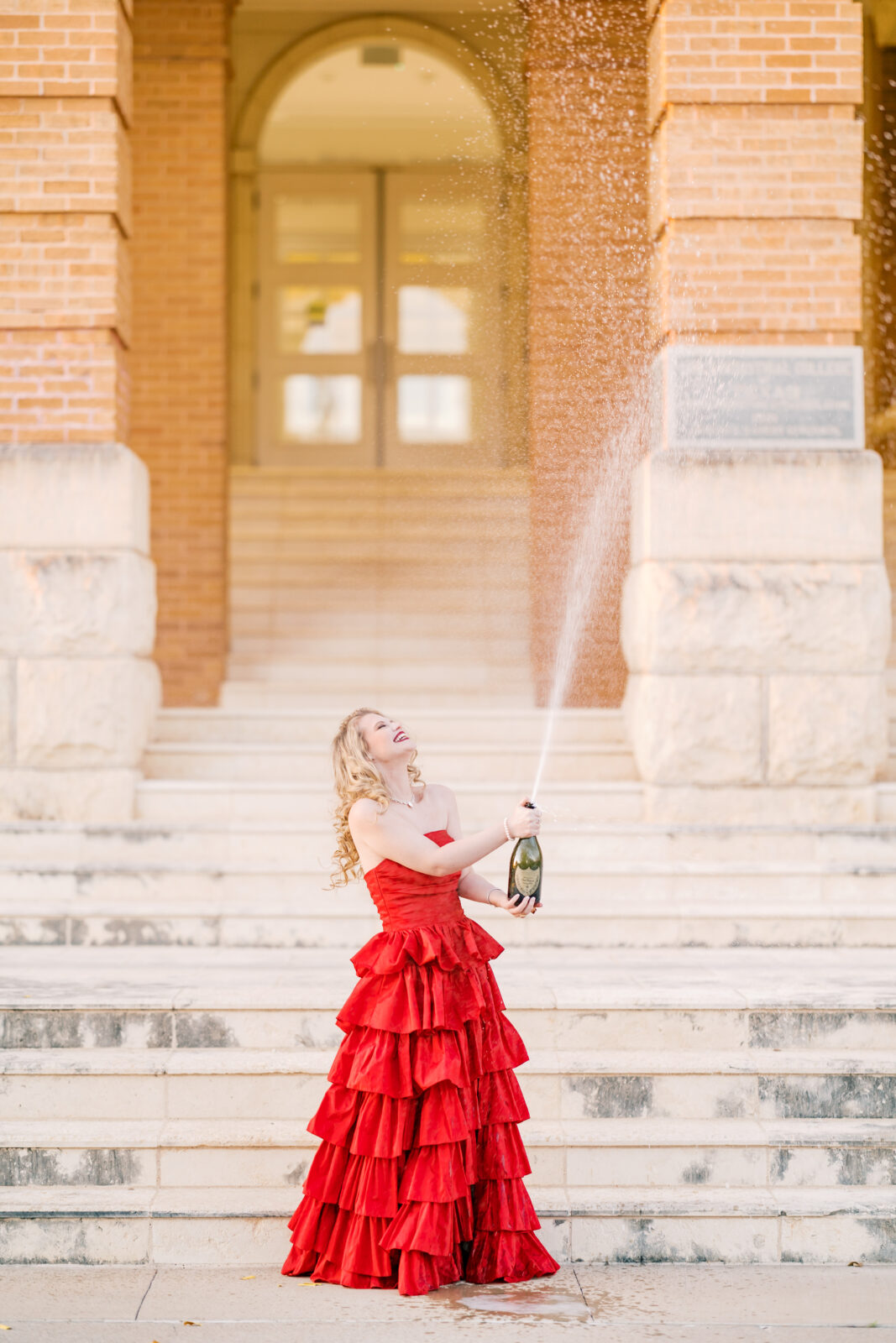 Avery pops a bottle of Dom Pérignon for her TWU graduation portraits.