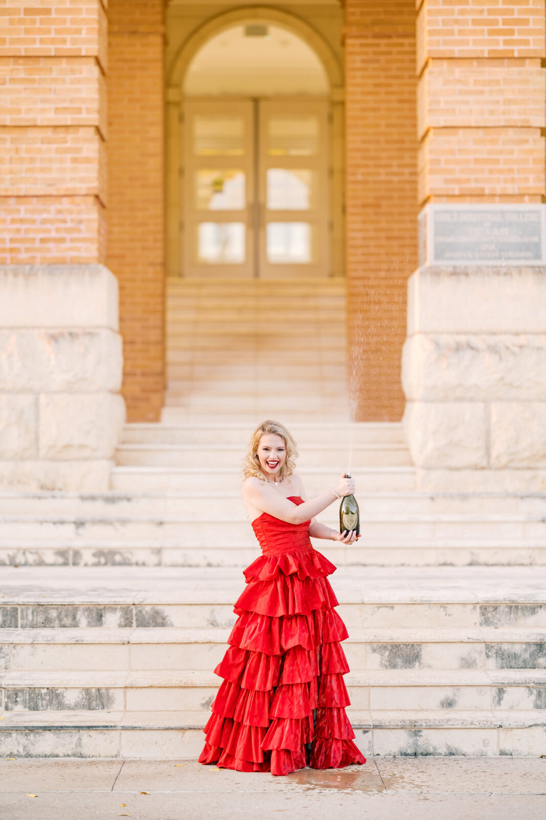 Avery pops a bottle of Dom Pérignon for her TWU graduation portraits.