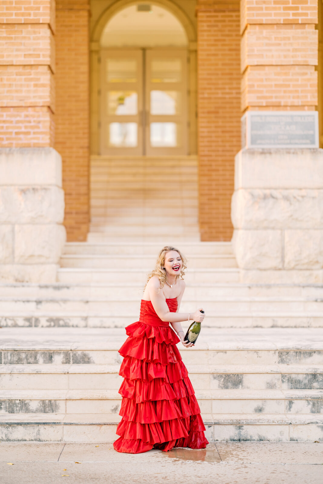 Avery pops a bottle of Dom Pérignon for her TWU graduation portraits.