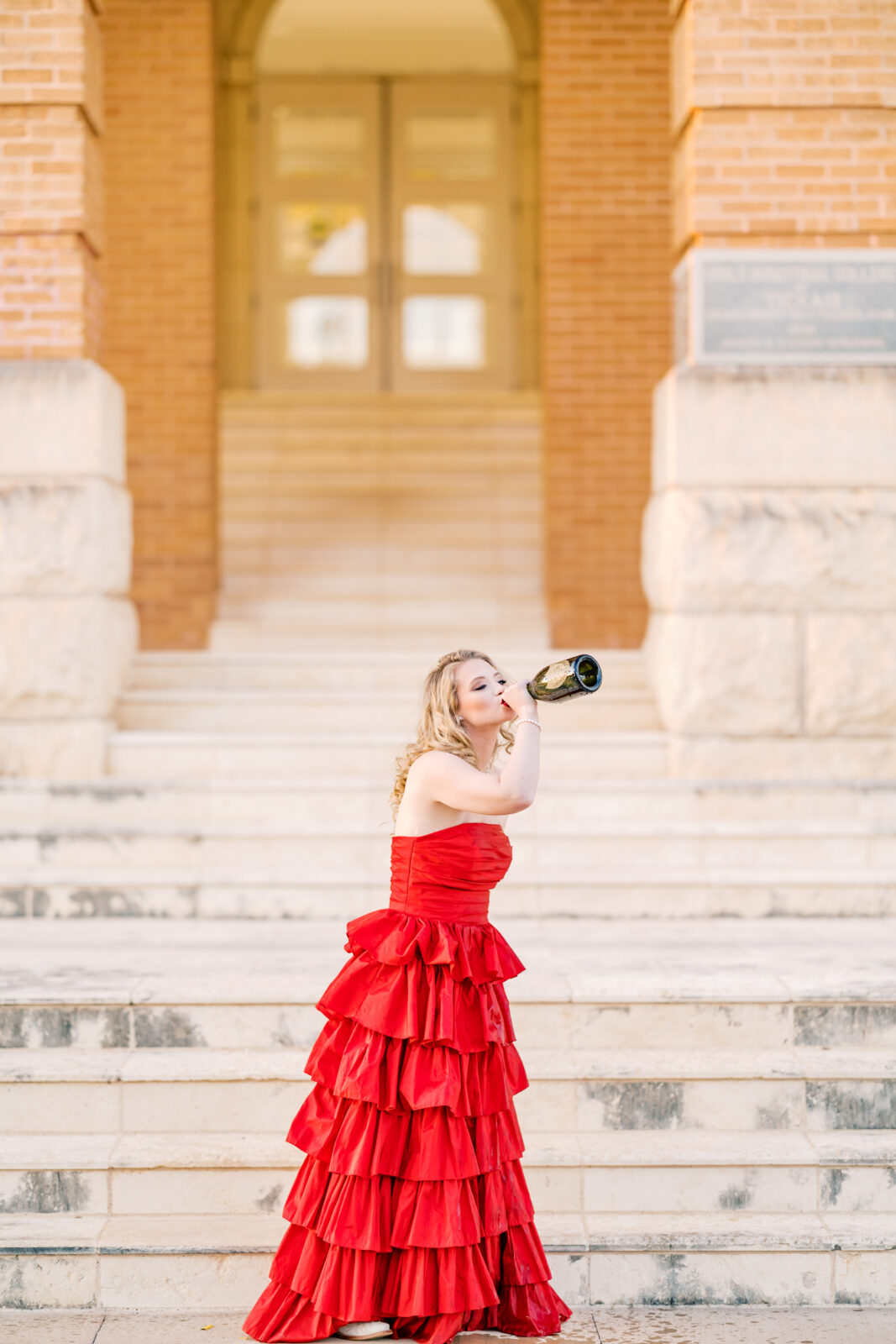 Avery pops a bottle of Dom Pérignon for her TWU graduation portraits.