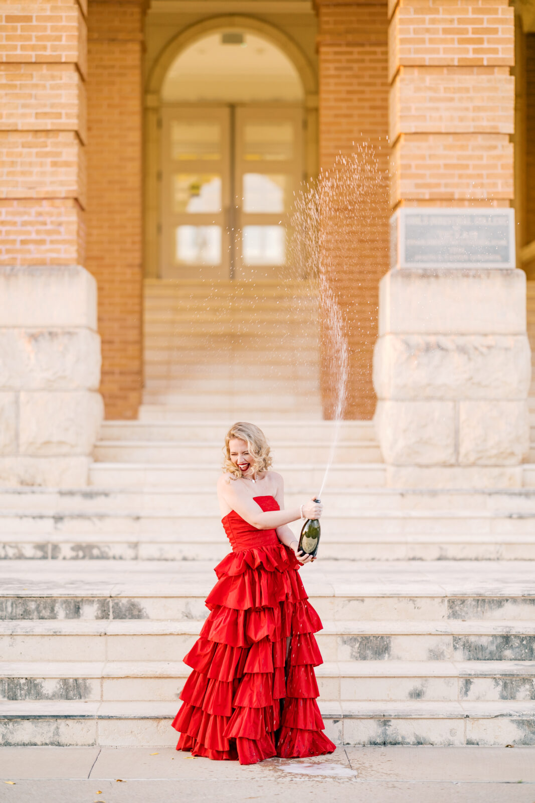 Avery pops a bottle of Dom Pérignon for her TWU graduation portraits.